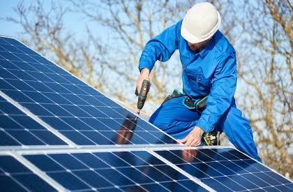 Technician fixing a photovoltaic panel on its structure